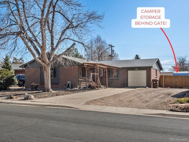 single story home featuring brick siding, driveway, a garage, and fence