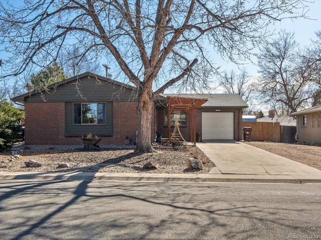 ranch-style home with a garage, brick siding, driveway, and fence