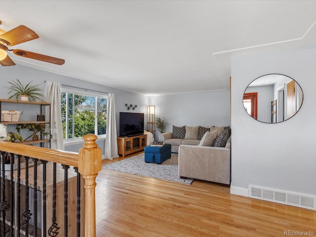 living room with a ceiling fan, wood finished floors, visible vents, and baseboards