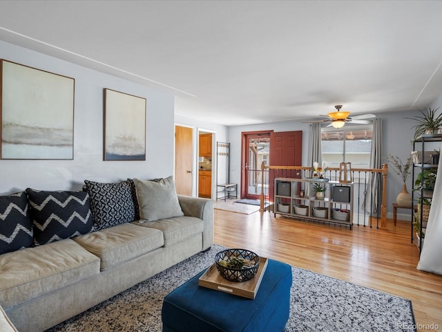 living room with light wood-type flooring and a ceiling fan