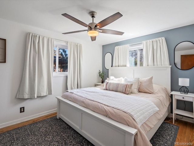 bedroom with a ceiling fan, baseboards, and wood finished floors