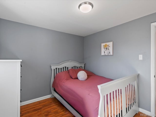 bedroom with baseboards and wood finished floors