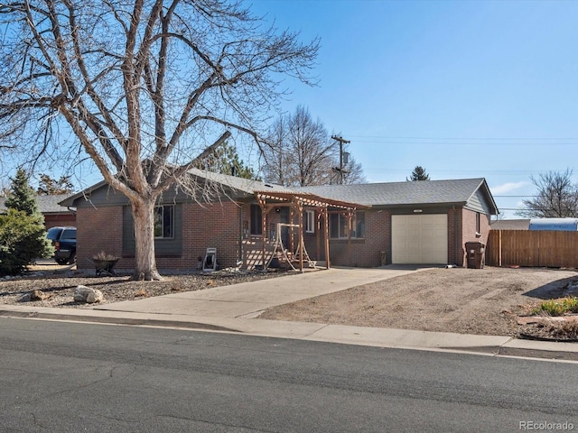 ranch-style house featuring an attached garage, fence, brick siding, and driveway