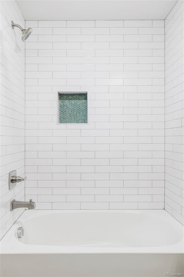 bathroom featuring tiled shower / bath