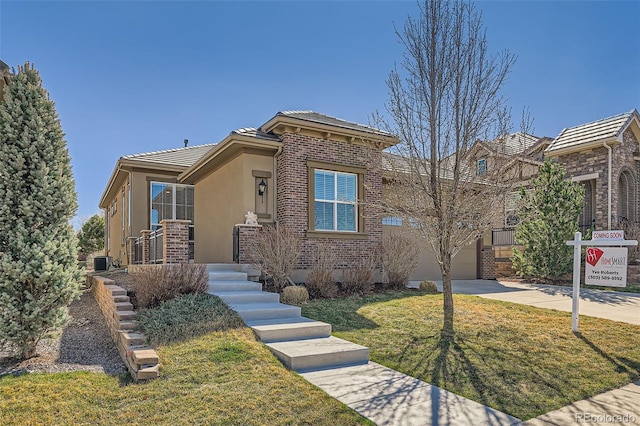 12114 Alcott St, Westminster, CO 80234 - view of front of property featuring concrete driveway, a front yard, a tiled roof, a garage, and stucco siding