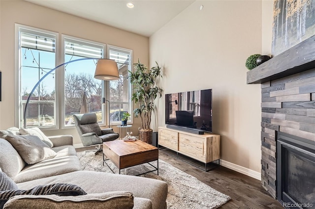 12114 Alcott St, Westminster, CO 80234 - living room featuring baseboards, a stone fireplace, dark wood-type flooring, vaulted ceiling, and recessed lighting