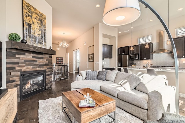 12114 Alcott St, Westminster, CO 80234 - living area featuring a chandelier, dark wood-style flooring, plenty of natural light, a glass covered fireplace, and recessed lighting
