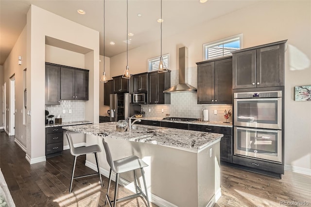 12114 Alcott St, Westminster, CO 80234 - kitchen featuring stainless steel appliances, wall chimney range hood, a sink, dark wood-style flooring, and recessed lighting