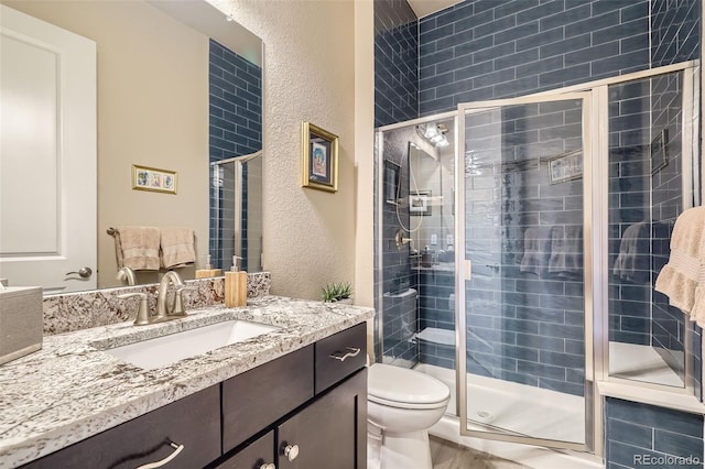 12114 Alcott St, Westminster, CO 80234 - full bathroom featuring a stall shower, toilet, vanity, and a textured wall