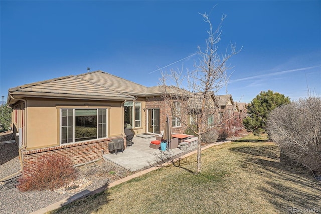 12114 Alcott St, Westminster, CO 80234 - rear view of property featuring a patio area, brick siding, a tiled roof, a yard, and stucco siding