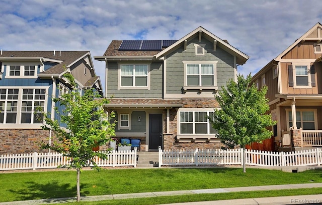 craftsman inspired home with a front yard and solar panels