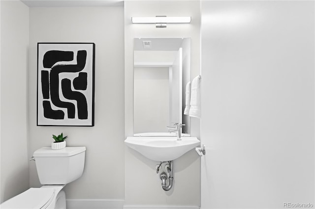 bathroom with toilet and baseboards