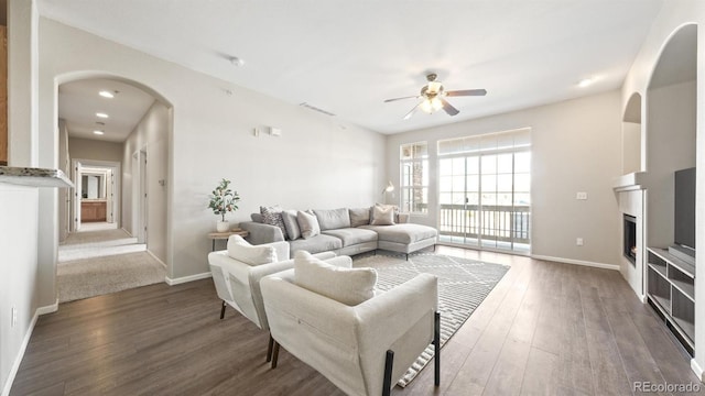 living room featuring dark wood-type flooring and ceiling fan