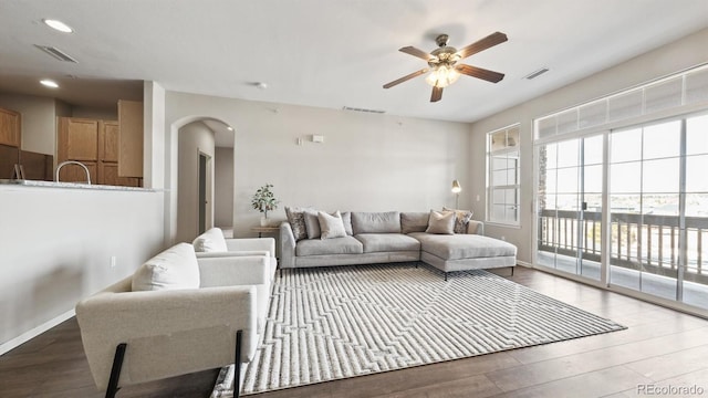 living room featuring sink, hardwood / wood-style flooring, and ceiling fan