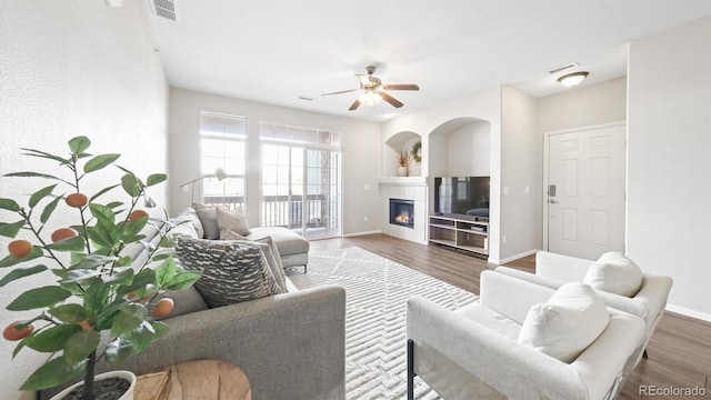 living room with dark hardwood / wood-style flooring, a fireplace, and ceiling fan