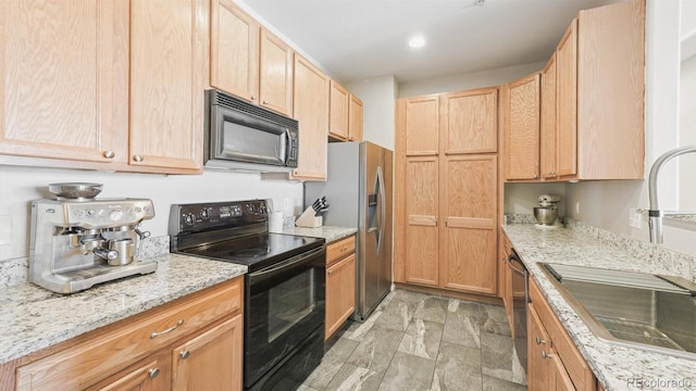 kitchen with light brown cabinetry, sink, light stone countertops, and black appliances