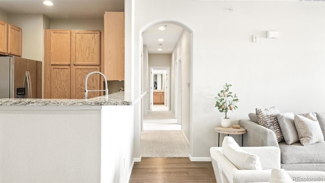 hall featuring wood-type flooring and sink