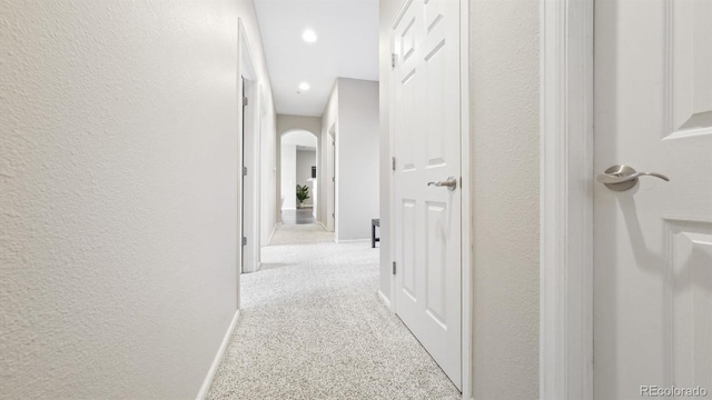 hallway featuring light colored carpet