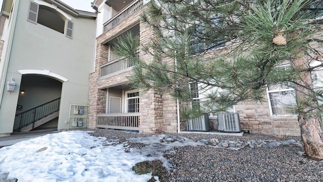 snow covered property with central AC unit