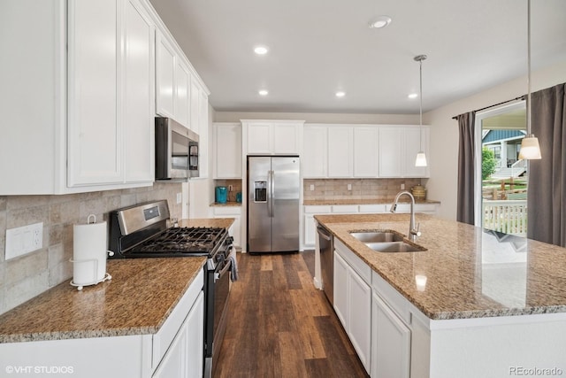 1143 Williams Loop, Elizabeth, CO 80107 - kitchen with stainless steel appliances, dark wood-style flooring, white cabinets, decorative backsplash, and a kitchen island with sink