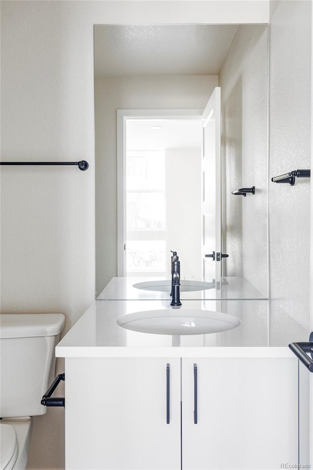 bathroom featuring vanity and toilet