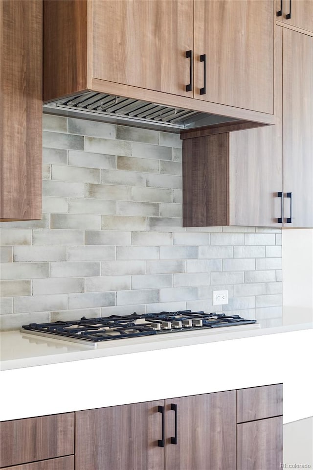 room details featuring decorative backsplash and stainless steel gas stovetop