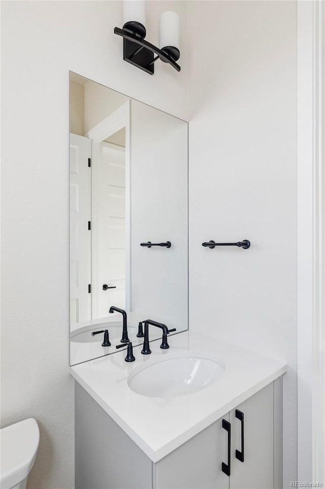 bathroom featuring vanity and toilet