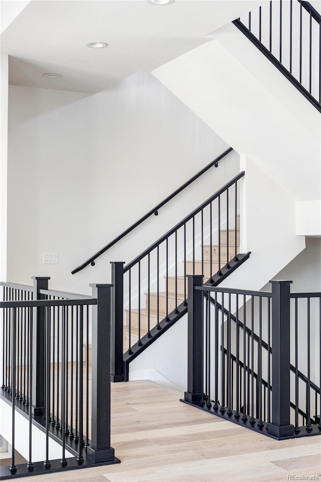 staircase with hardwood / wood-style floors