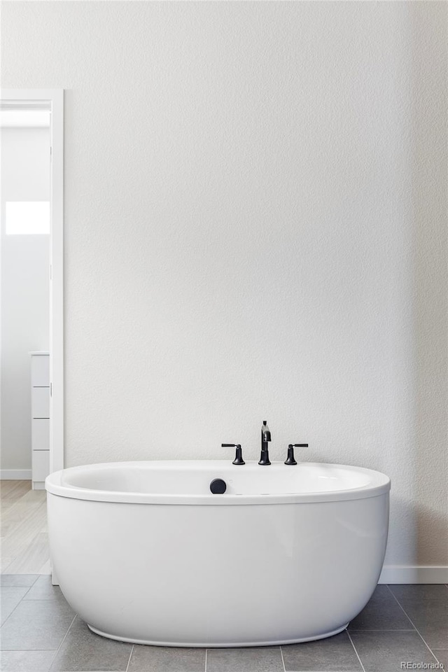 bathroom featuring tile patterned flooring and a bath