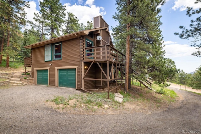 153 Divide View Dr, Golden, CO 80403 - view of side of home featuring dirt driveway, stairs, a garage, a deck, and log siding