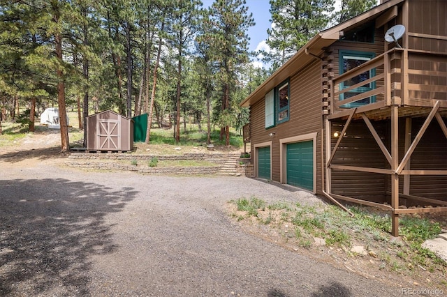 153 Divide View Dr, Golden, CO 80403 - view of property exterior featuring a shed, an attached garage, driveway, a wooden deck, and log exterior
