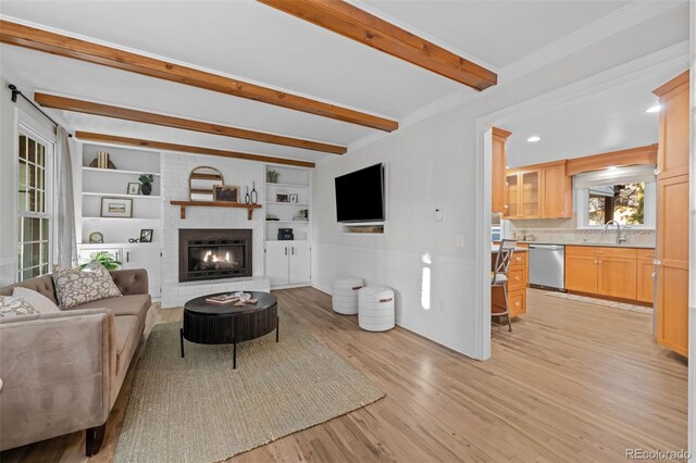 2684 Taft Ct, Lakewood, CO 80215 - living room featuring beamed ceiling, light wood-type flooring, a fireplace, built in shelves, and a wainscoted wall