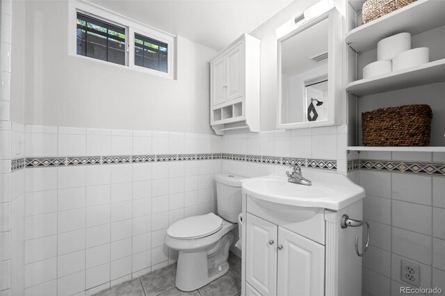 2684 Taft Ct, Lakewood, CO 80215 - bathroom with tile walls, vanity, toilet, tile patterned floors, and wainscoting
