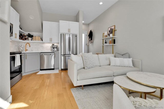 living room featuring light hardwood / wood-style flooring and sink