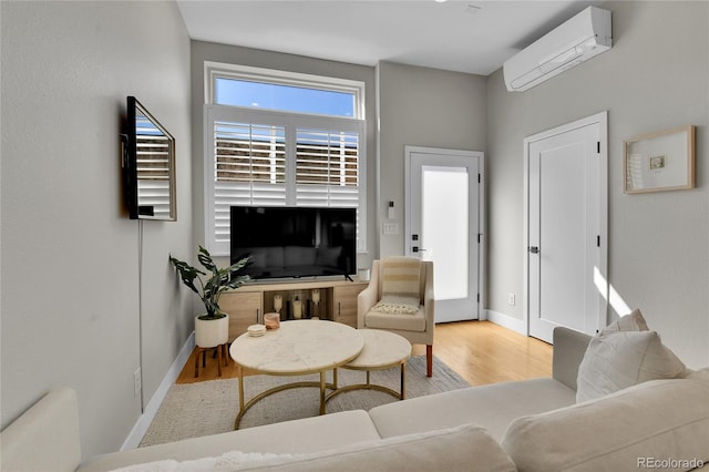 living room featuring light hardwood / wood-style floors and a wall unit AC