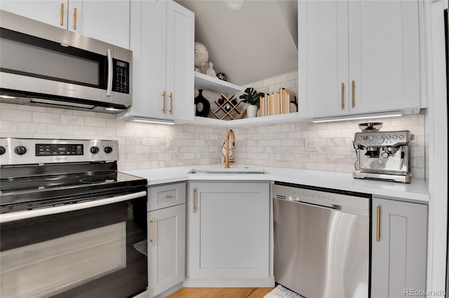 kitchen featuring sink, white cabinets, appliances with stainless steel finishes, and tasteful backsplash