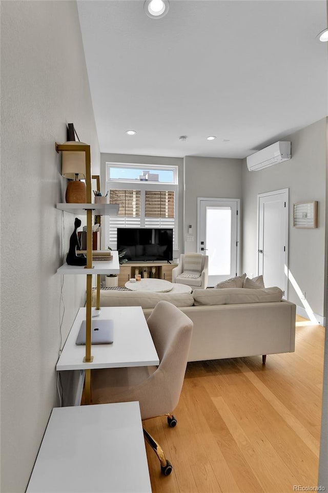 living room with wood-type flooring and a wall mounted air conditioner