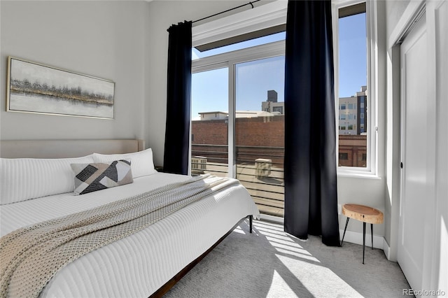 bedroom with light colored carpet and multiple windows