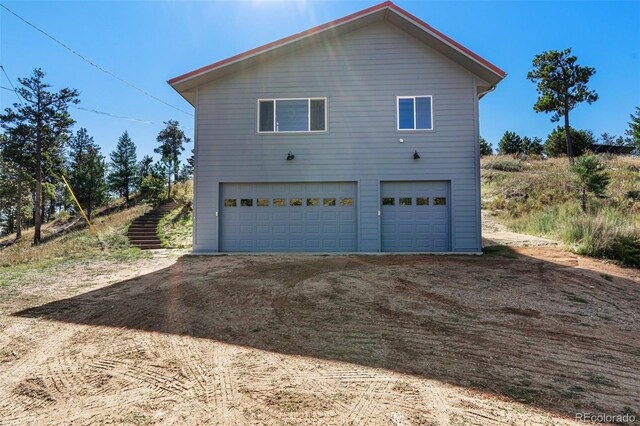 319 Camino Bosque, Boulder, CO 80302 - view of side of home featuring dirt driveway and an attached garage