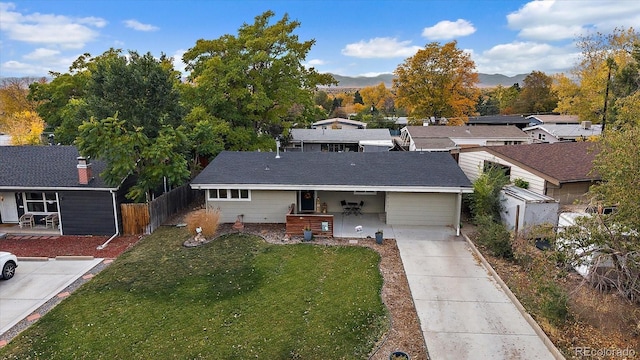 view of front of property featuring driveway, a front lawn, and fence