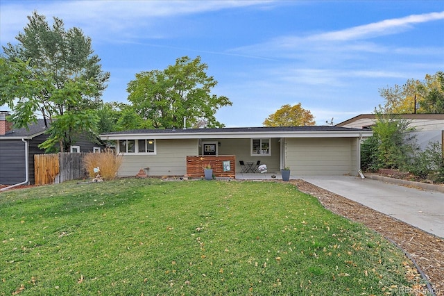 rear view of property featuring driveway, a yard, and fence