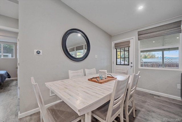 dining area with baseboards, visible vents, and light wood finished floors