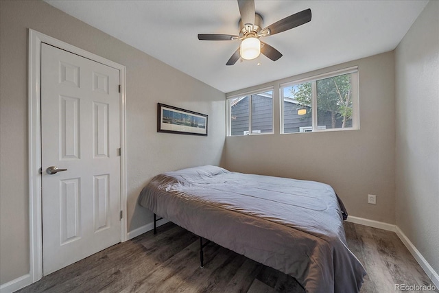 bedroom with ceiling fan, baseboards, and dark wood-style floors