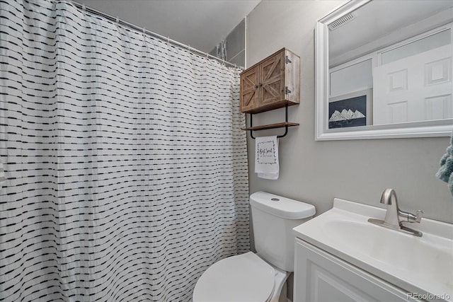 bathroom featuring a shower with shower curtain, visible vents, toilet, and vanity