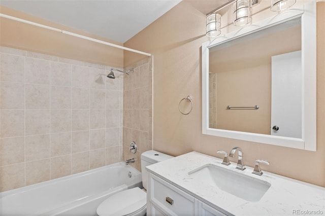 full bathroom featuring vanity, tiled shower / bath, and toilet