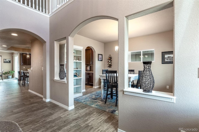 interior space featuring wood finished floors, baseboards, and a textured wall