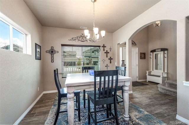 dining space with an inviting chandelier, visible vents, baseboards, arched walkways, and dark wood-style floors