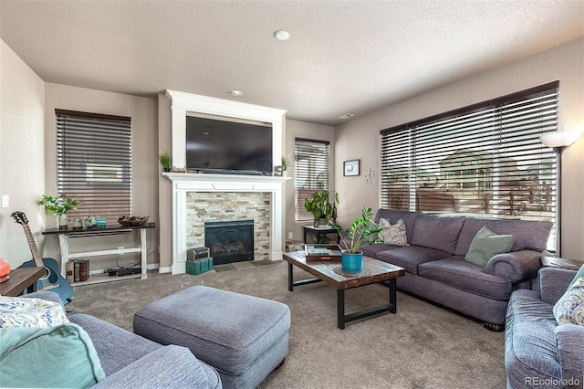 carpeted living area with a textured ceiling and a tile fireplace