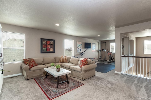 carpeted living room with a textured ceiling, baseboards, visible vents, and recessed lighting