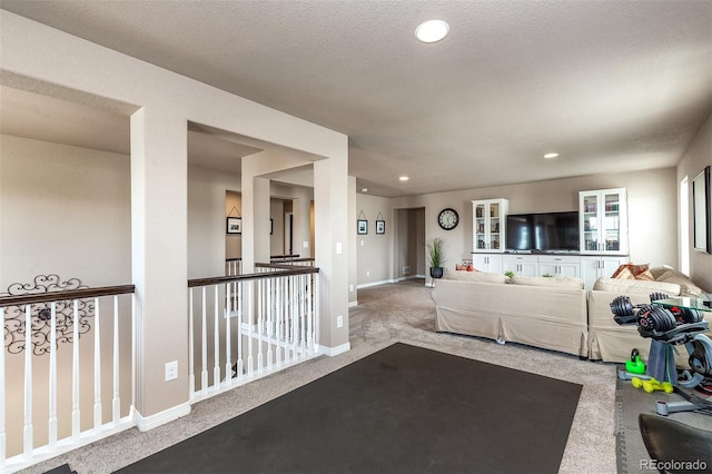 carpeted living area with baseboards and recessed lighting